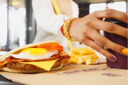 Quick breakfast pita with fried egg, bacon and cheese, served with chips and a drink