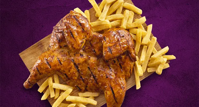 The Steers chicken meals on a grey surface with a purple background