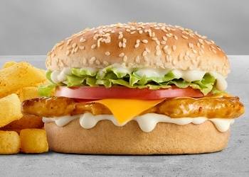 Grilled chicken cheeseburger with melted cheddar cheese, lettuce, tomato, creamy mayo sauce, sesame seed bun, and chips