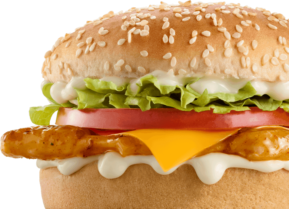 Close-up grilled chicken cheeseburger with melted cheddar cheese, fresh lettuce, tomato slices, creamy mayonnaise sauce, and sesame seed bun