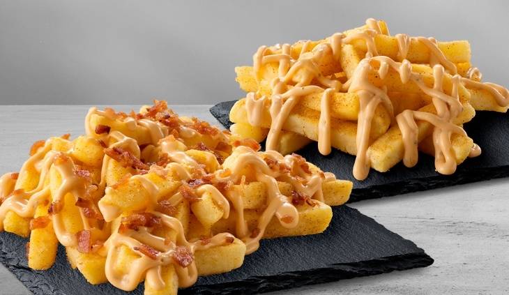 Loaded seasoned hand-cut chips topped with creamy sauce and crispy bacon bits, served on black slate boards