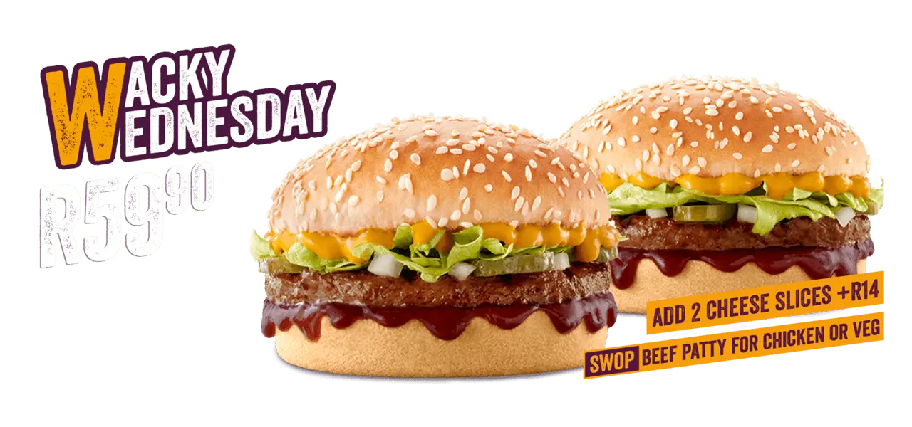 2 Beef Wacky Wednesday burgers with mustard placed on a purple surface with a grey background. 